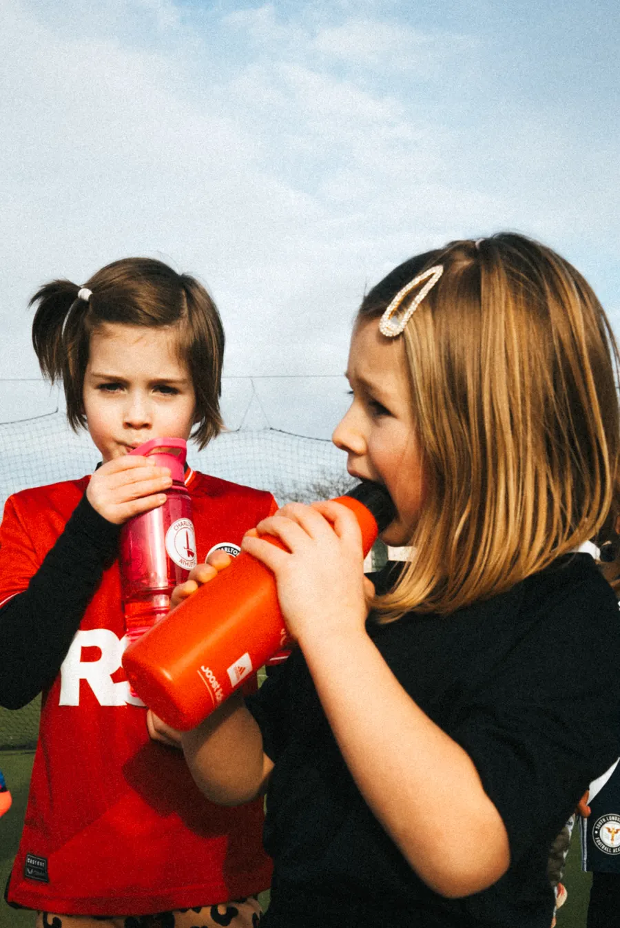 Two young players sharing a water break