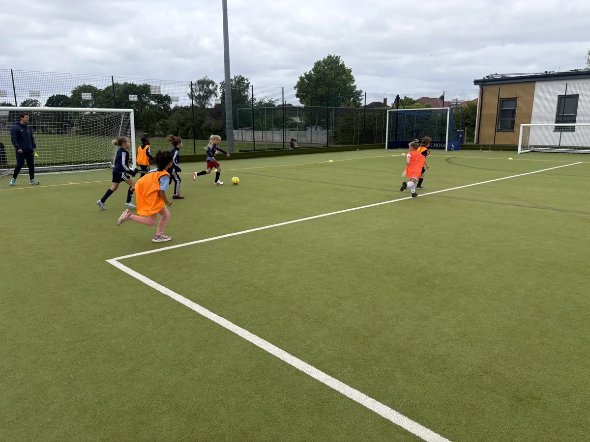 Under 7 girls playing 3v3 football in bibs
